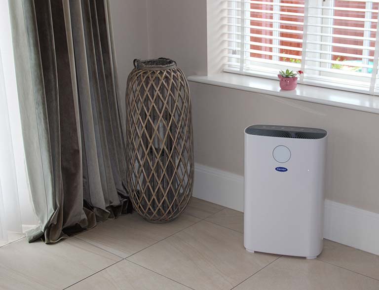 A compact Carrier air cleaner equipped with UV-C and activated carbon filters for use in small offices and homes.
